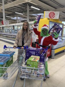 Georgia Stretton, 32West’s Social Media Specialist, and the Grinch getting into the festive spirit as she shops for items for Liverpool foodbanks